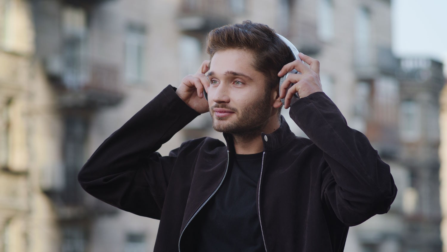 Hombre se pone unos auriculares en la calle